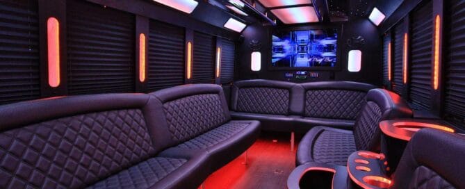 Party bus interior with wraparound seating and colored ceiling lighting